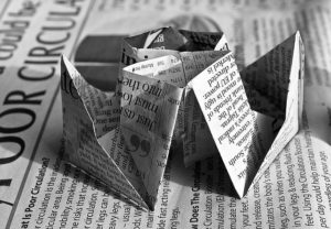 This is a photograph of a piece of newspaper that has been folded into origami.