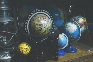 This is a photograph of half a dozen small globes sitting on a shelf.