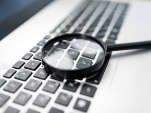 Magnifying glass on a computer keyboard.